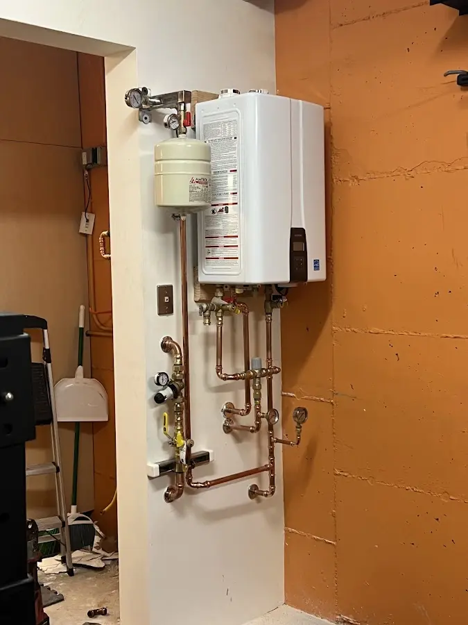 Plumbing technician inspecting water heater connections in Storm Lake